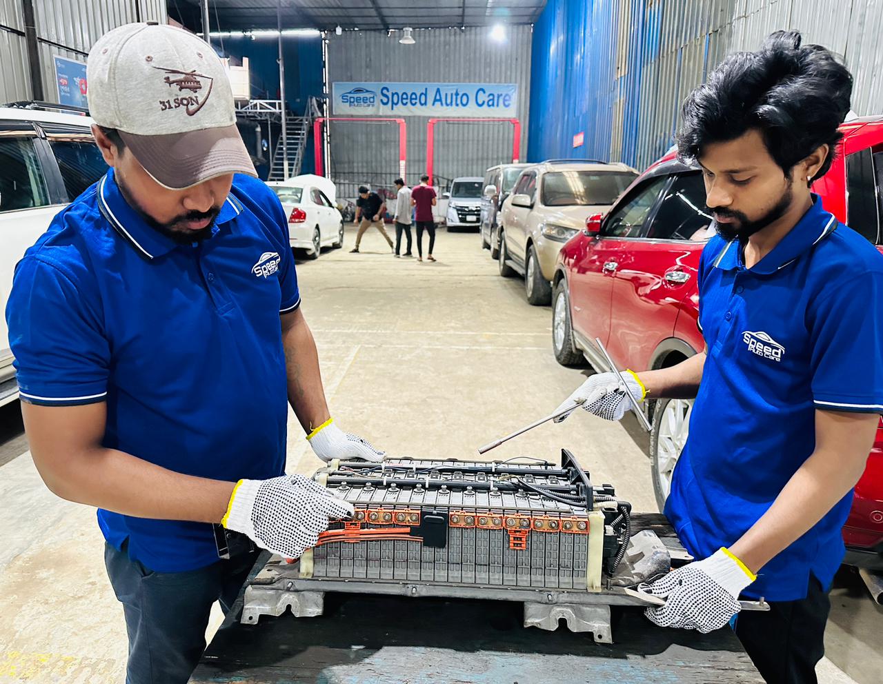Two technicians servicing a hybrid battery pack