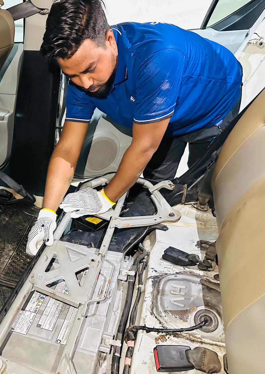 Technician removing a hybrid battery pack for diagnosis